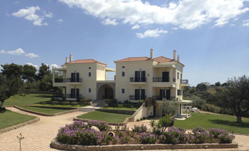 una grande casa con un giardino di fronte di Long View Hammam & Spa a Porto Heli