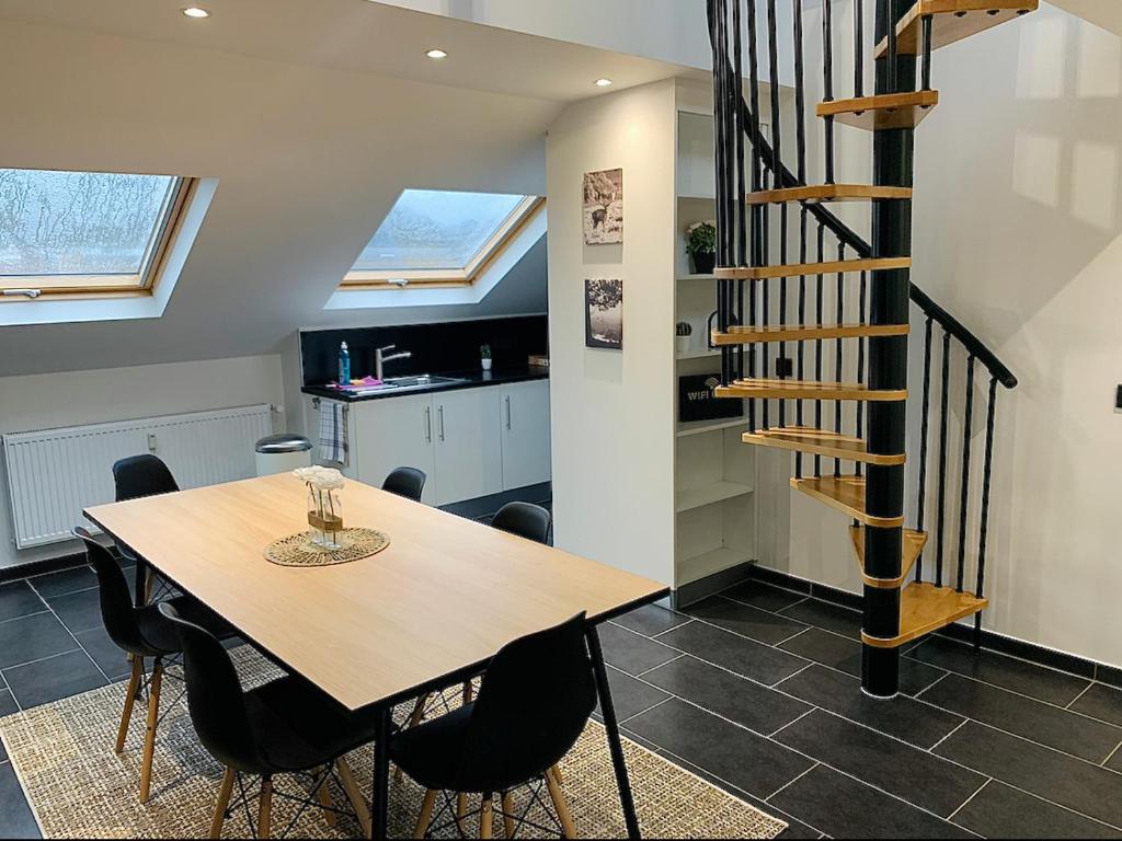 a dining room with a wooden table and black chairs at Esch/Alzette city apartment in Esch-sur-Alzette