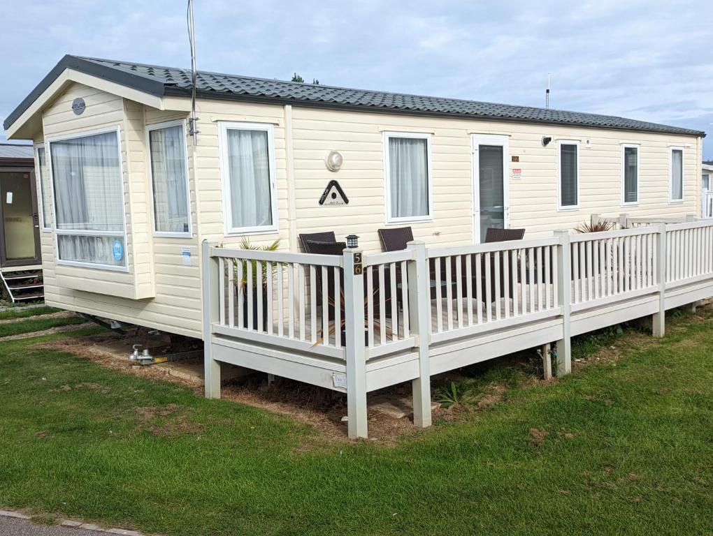 a white mobile home with a white fence at Beachhome in Heacham