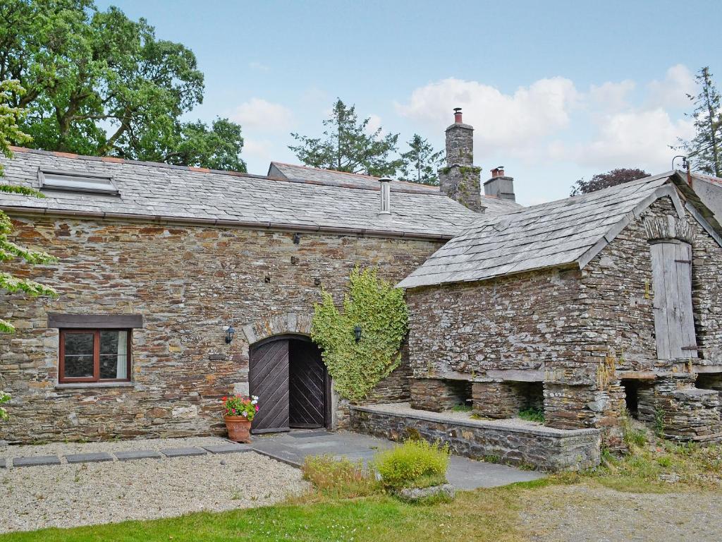 un antiguo edificio de piedra con una puerta grande en The Granary en Egloskerry