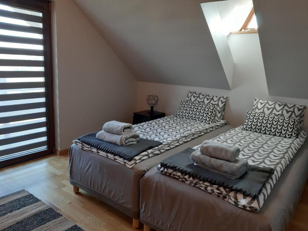 2 camas individuales en una habitación con ventana en Siedlisko na Winnicy en Opatów