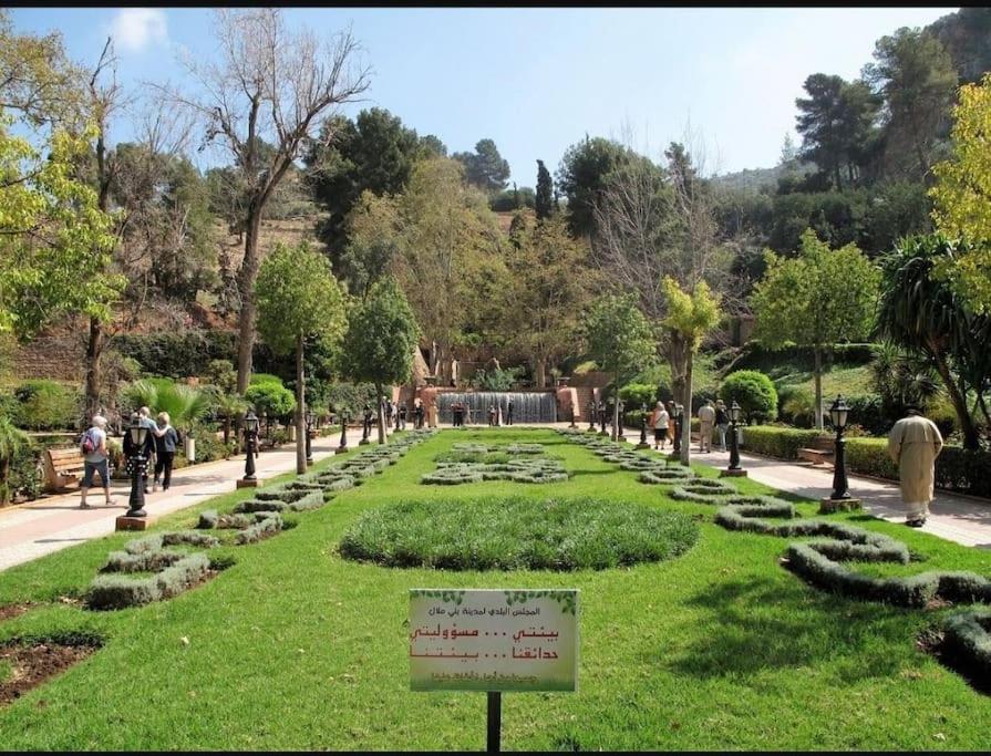 un jardín en un parque con un cartel en el césped en cosy appartement au Centre de la ville avec WIFI, en Beni Mellal