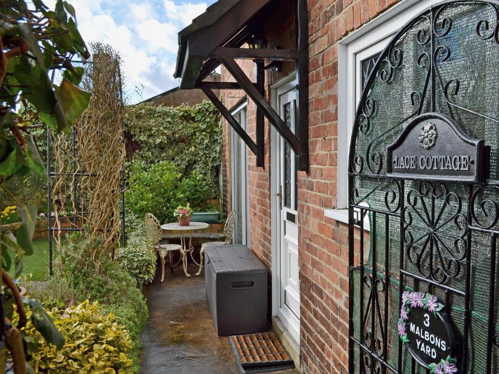 a gate to a house with a table outside at Lace Cottage in Ashbourne
