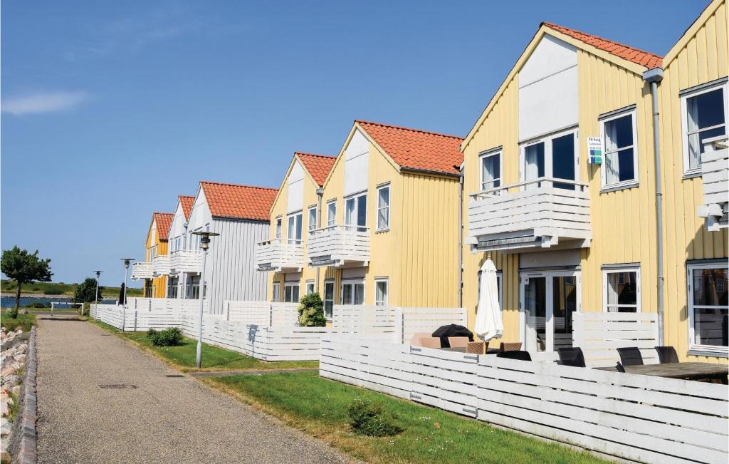 une rangée de maisons jaunes et blanches dans l'établissement 2 Bedroom Nice Apartment In Rudkbing, à Rudkøbing