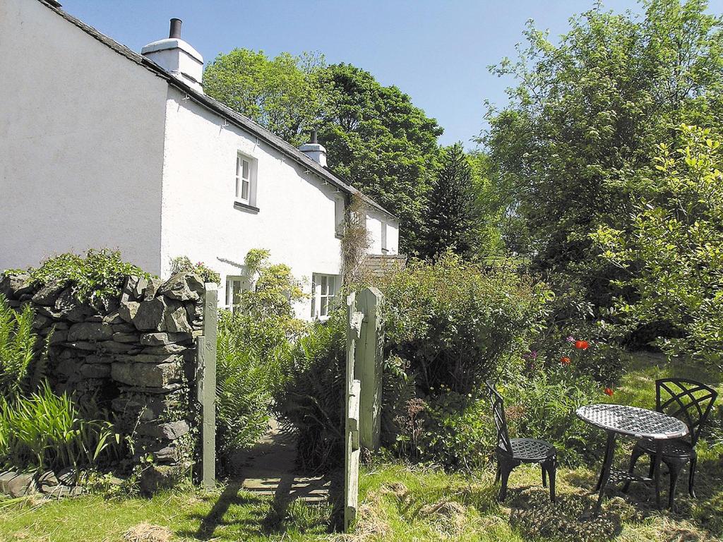 a house with a table and chairs in front of it at Cragg Cottage in Bouth