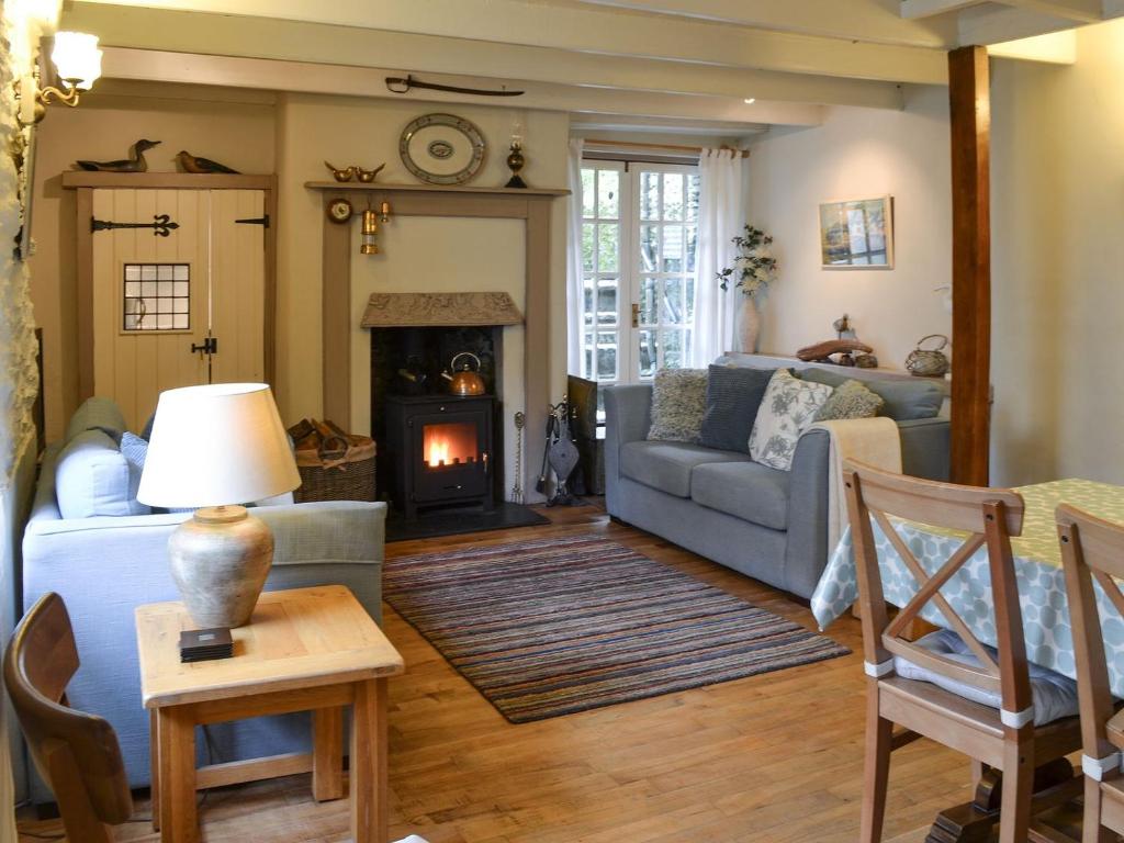 a living room with a couch and a fireplace at Fairmaiden in Polruan