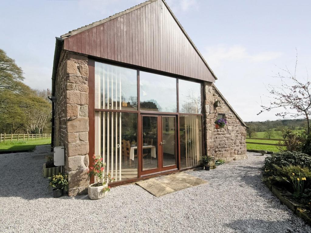 a stone cottage with large glass doors on it at The Granary - E5483 in Froghall
