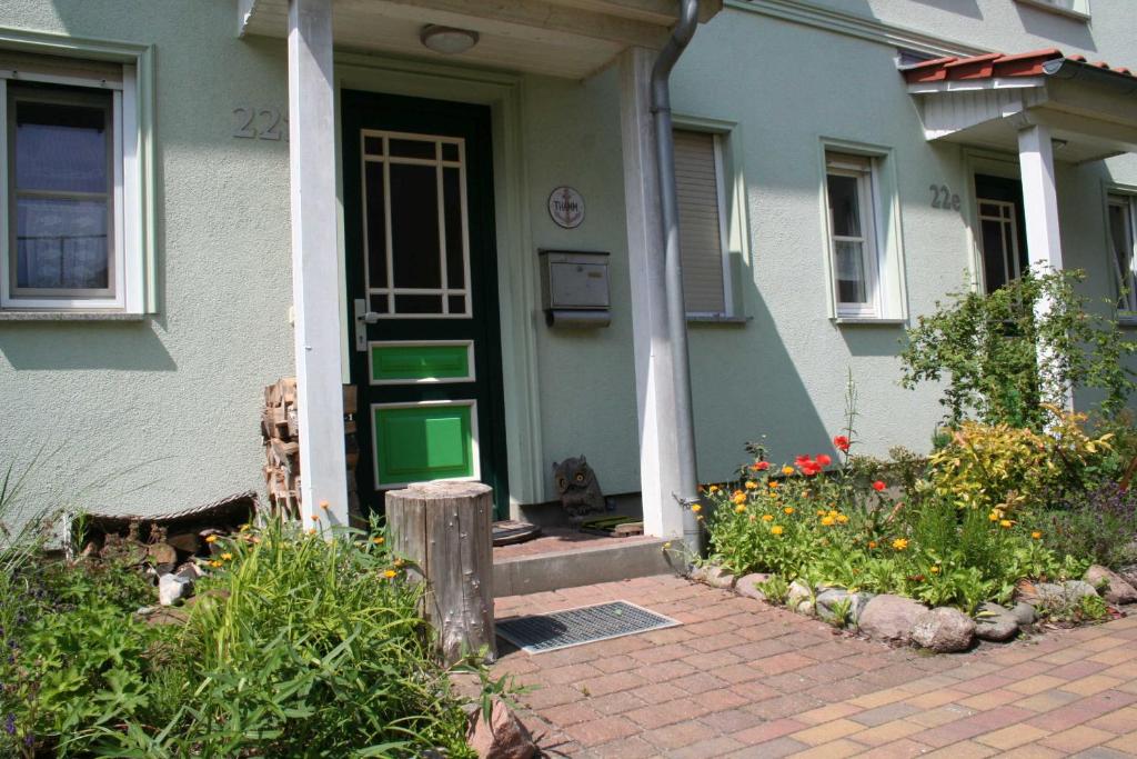una casa con una puerta verde y algunas flores en FH Nordlicht, en Wustrow