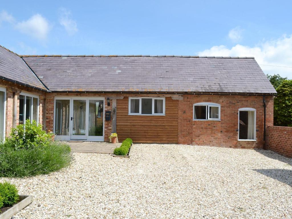 a brick house with a driveway in front of it at The Apple House in Alderminster