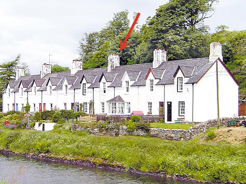 a large white building next to a river at Dunardry View in Lochgilphead