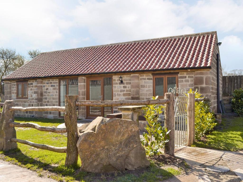 a stone house with a wooden gate and a fence at The Cartshed in Knaresborough