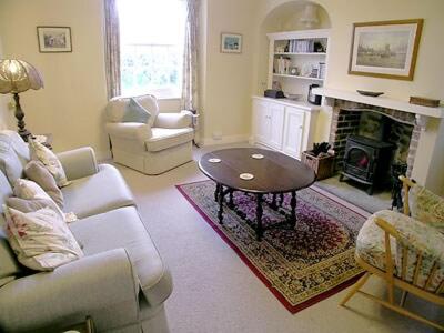 a living room with a couch and a table at Applewood Cottage in Loders