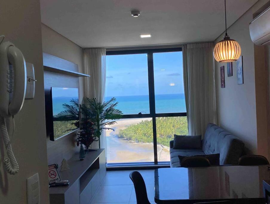 een woonkamer met uitzicht op de oceaan bij Apartamento no 20º andar Barra Home Stay in Recife