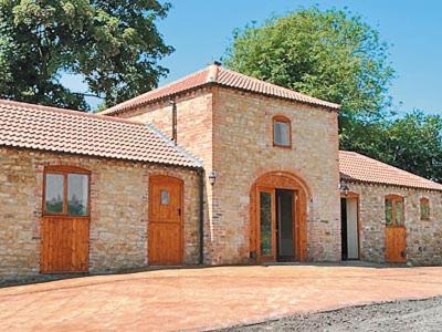 a brick building with two doors and a driveway at Wykham in Nettleton