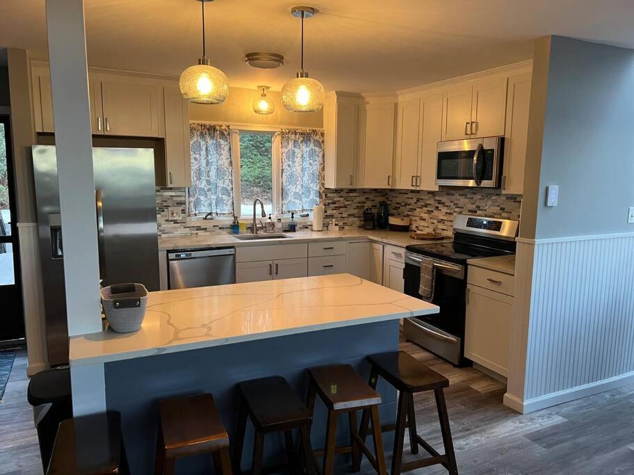 een keuken met een groot eiland met barkrukken bij Pocono Paradise - 3 bedroom 3 and half bathroom townhouse in Tannersville