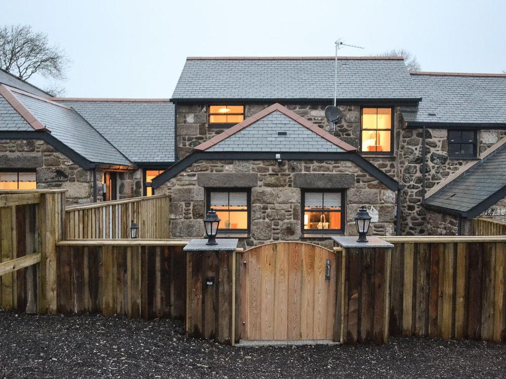 una casa con una valla de madera delante de ella en Chancer, en Newlyn