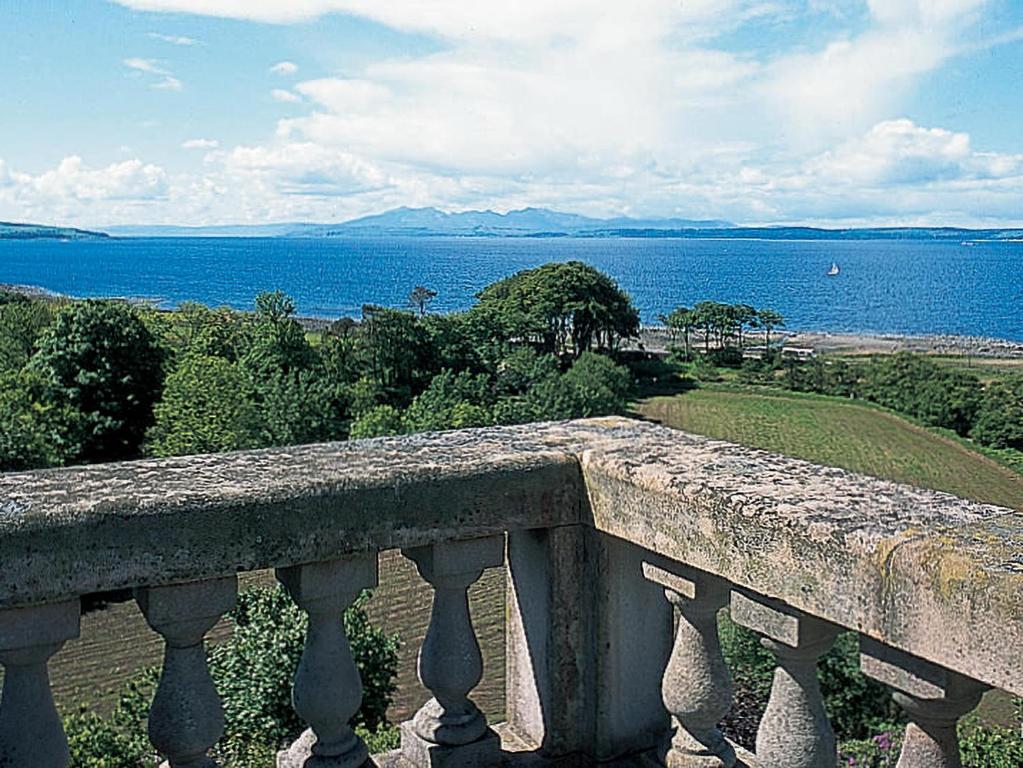 uma varanda de pedra com vista para a água em Glenfiddich em Largs