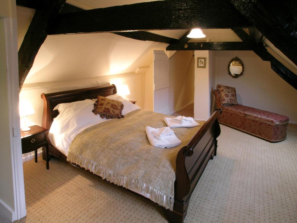 a bedroom with a large bed and a chair at Kings House in Beaumaris
