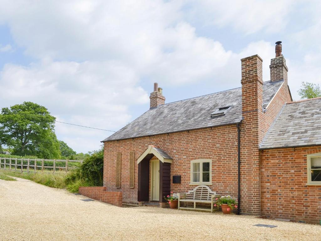 an old red brick house with a porch at Pond Cottage in Boldre