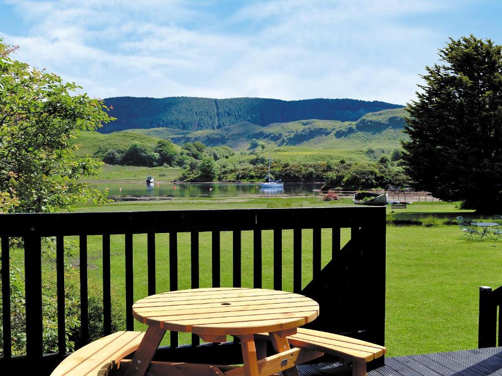a wooden table sitting on a balcony with a view of a river at Torsa - 28790 in Clachan