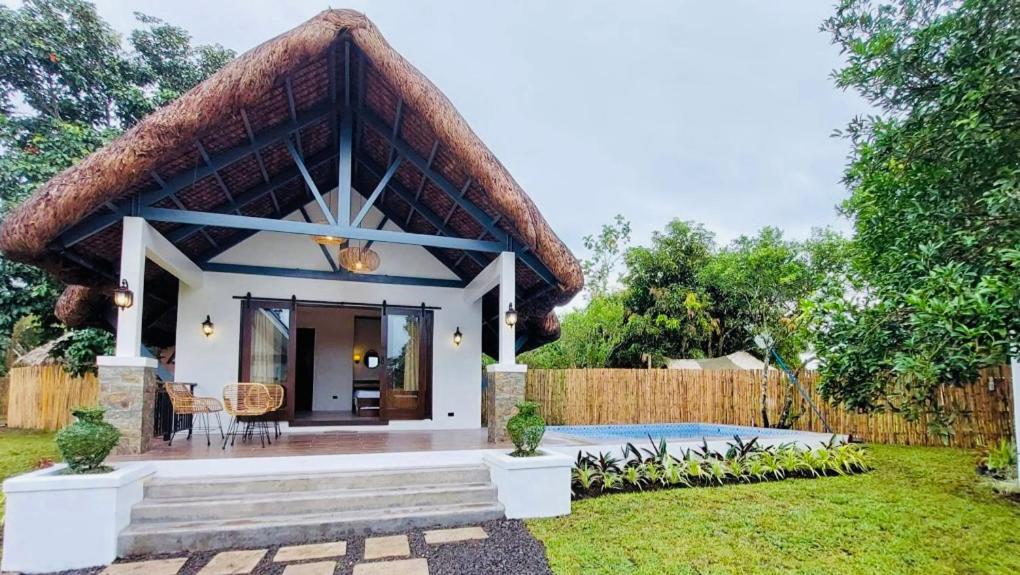 a small house with a thatched roof at White Hut Villas by Asog resort in Naga