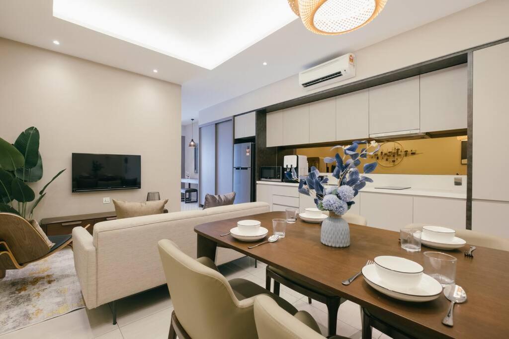 a kitchen and a living room with a table and chairs at Dorsett Hartamas KL with BathTub near MITEC MontKiara Publika in Kuala Lumpur