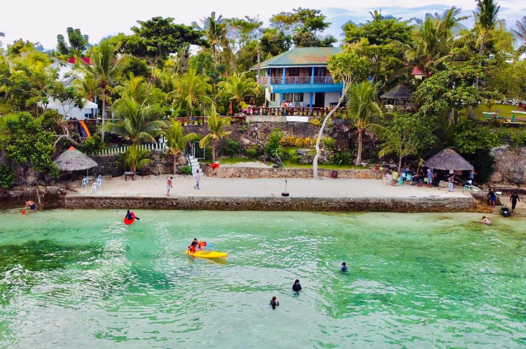 um grupo de pessoas na água em uma praia em La Concepcion Cove Garden Resort em Moalboal