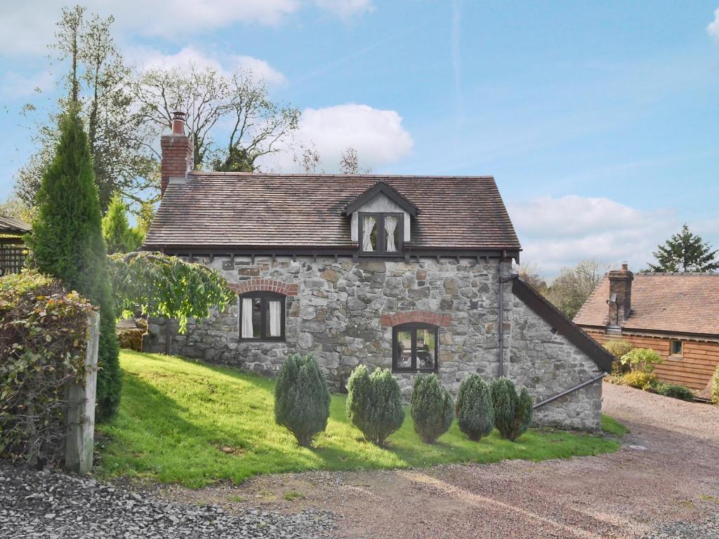 an old stone house in the middle of a yard at Angel Barn in Farden