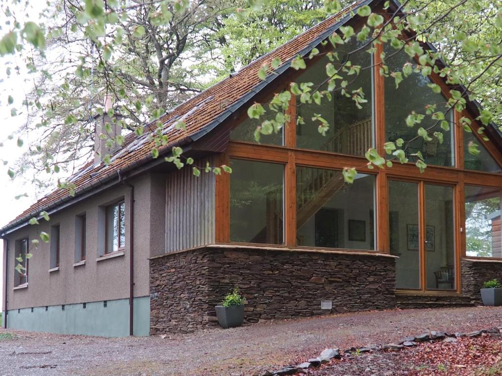 a house with a large glass window on the side of it at Scobach Lodge in Turriff