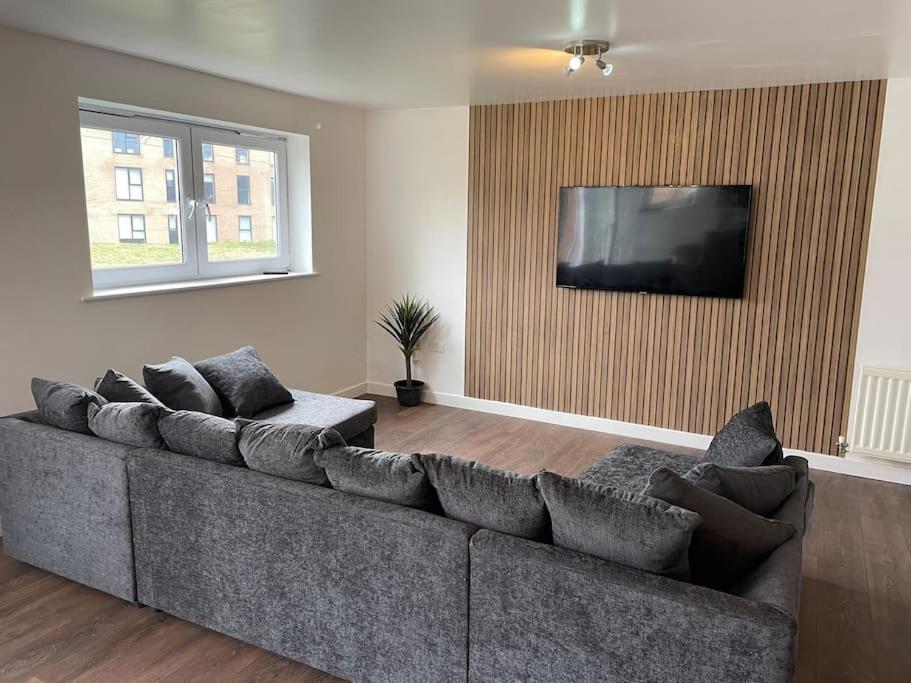 a living room with a couch and a flat screen tv at Stunning Central Apartment With Free Parking in Sheffield