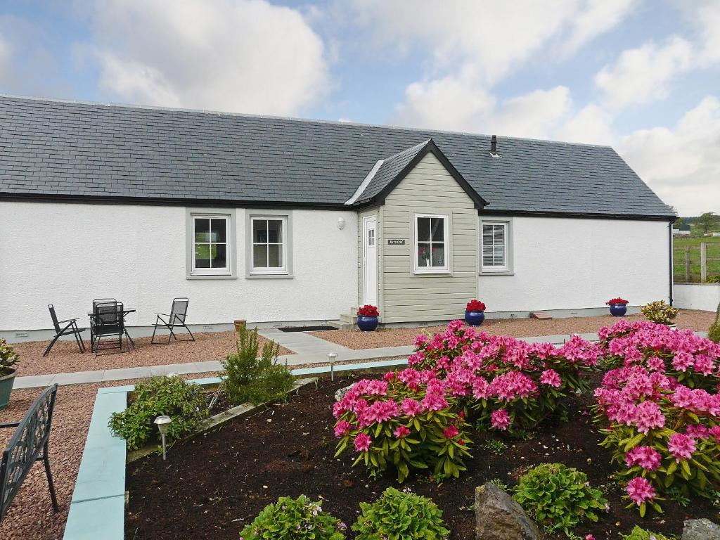 una casa blanca con flores en un jardín en Barn Owl Cottage - 27941, en Cambusbarron