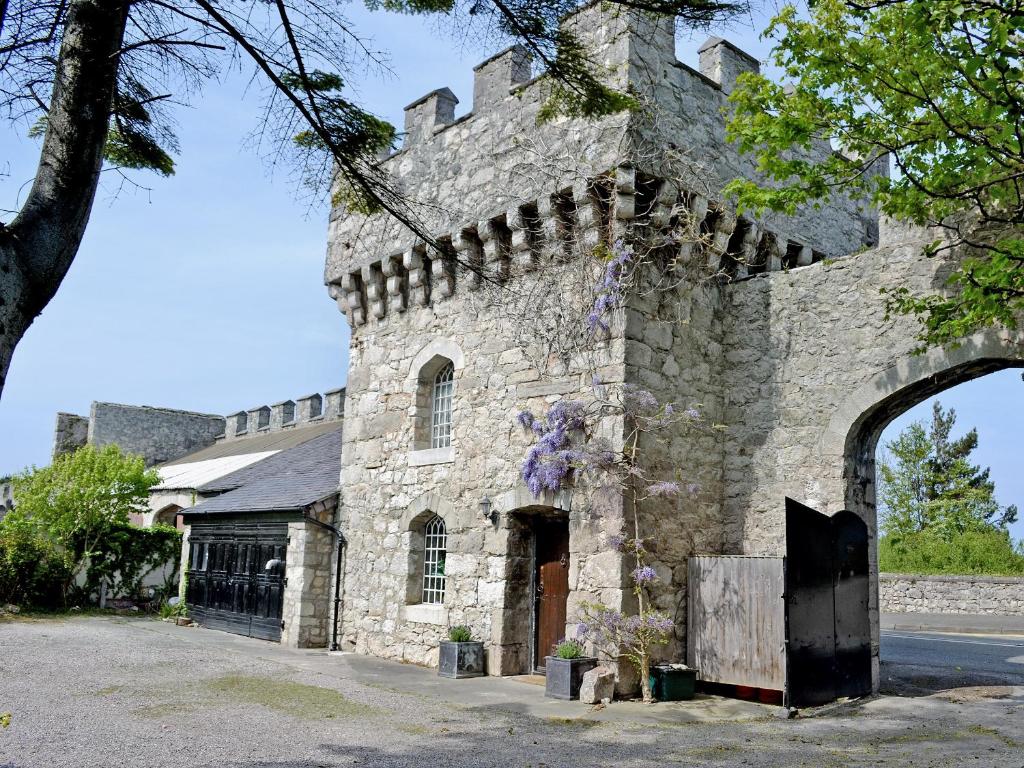 um grande edifício de pedra com uma porta em arco em Hen Wrych Hall Tower em Abergele