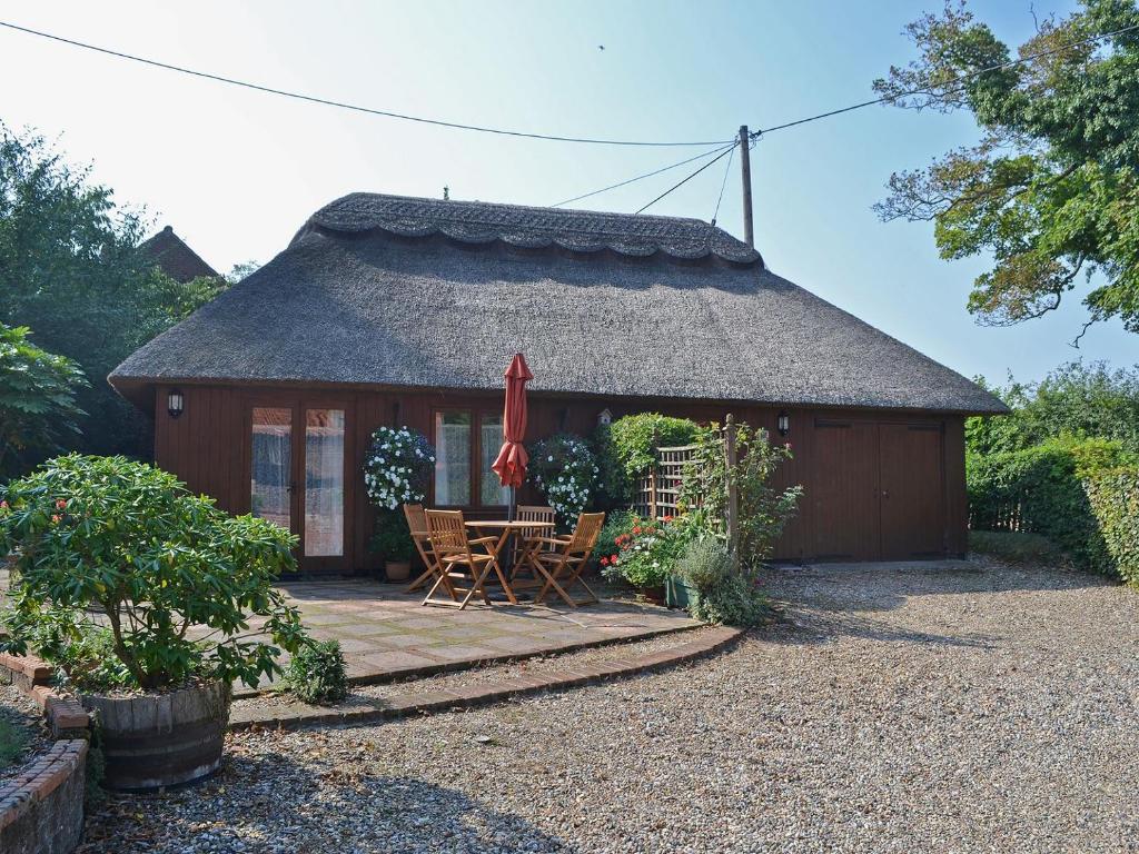 Casa pequeña con techo con mesa y sillas en Church Barn Studio en Brundall