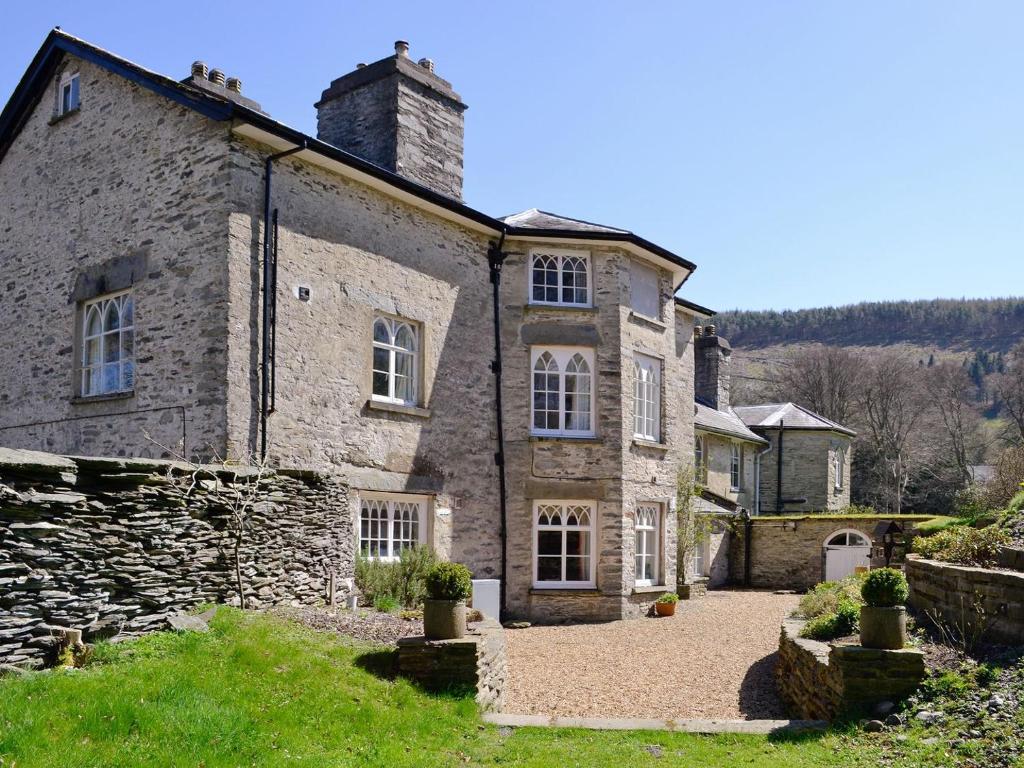 an old stone house with a stone driveway at Crogen Wing in Llandrillo