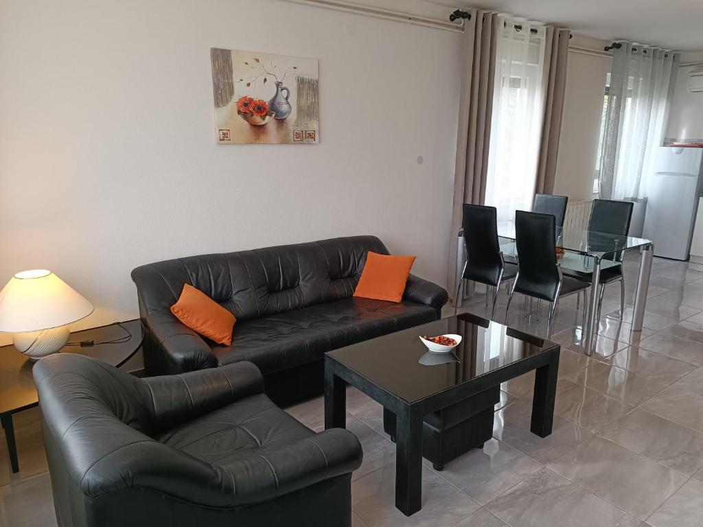 ein Wohnzimmer mit einem Sofa, Stühlen und einem Tisch in der Unterkunft Apartments Mira Krk in Krk
