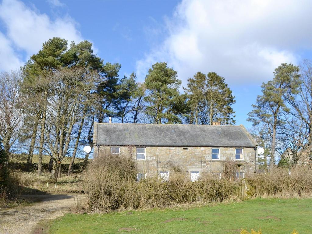 una vieja casa de piedra en medio de un campo en Oak Cottage-16498, en Catcleugh