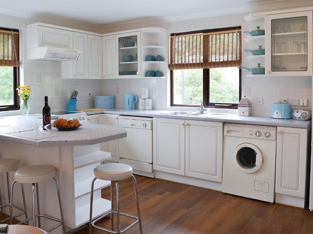 a white kitchen with a sink and a dishwasher at Rosecraddoc Manor - Lakeview in Saint Cleer