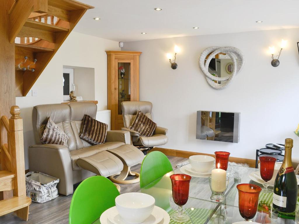 a living room with a table and a couch at Lily Vale Cottage in Hendy