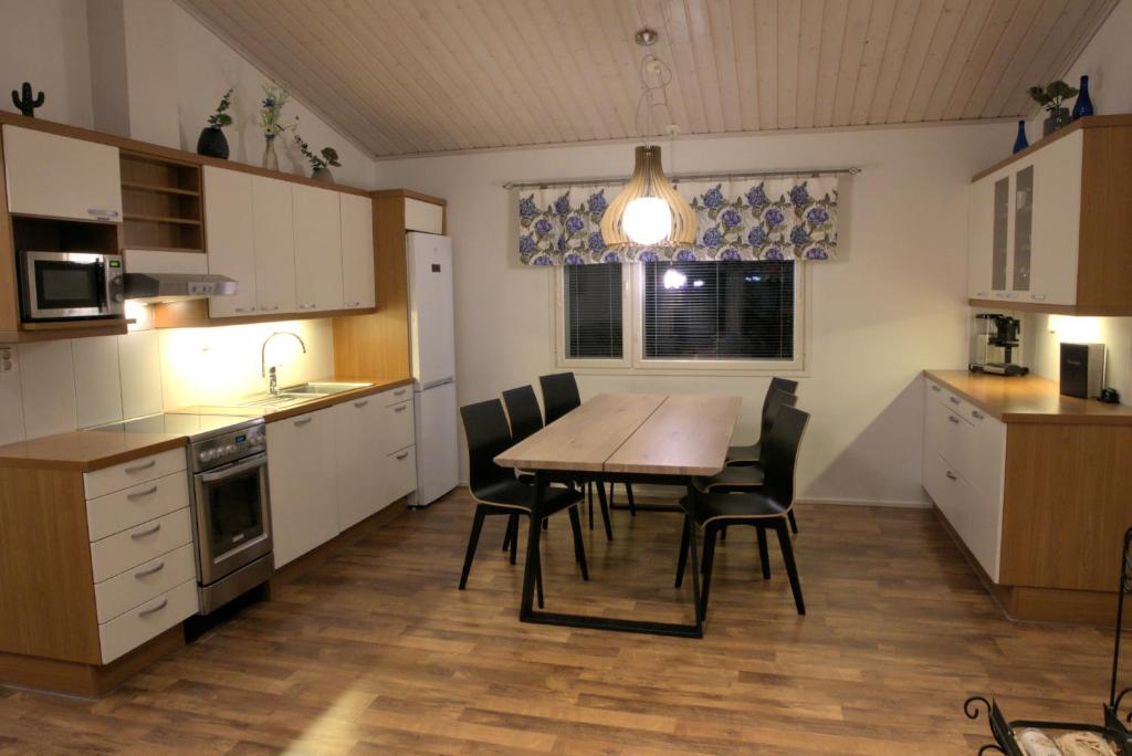 a kitchen with a table and chairs in a room at Villa Mustikkakumpu in Sonka