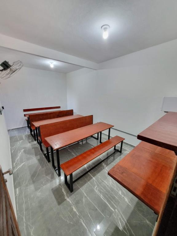 a row of tables and benches in a room at Pousada Iasbeck in Santa Rita de Jacutinga