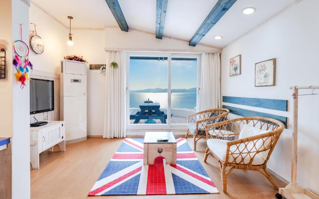 a living room with a view of the ocean at Soulmate Pension in Namhae