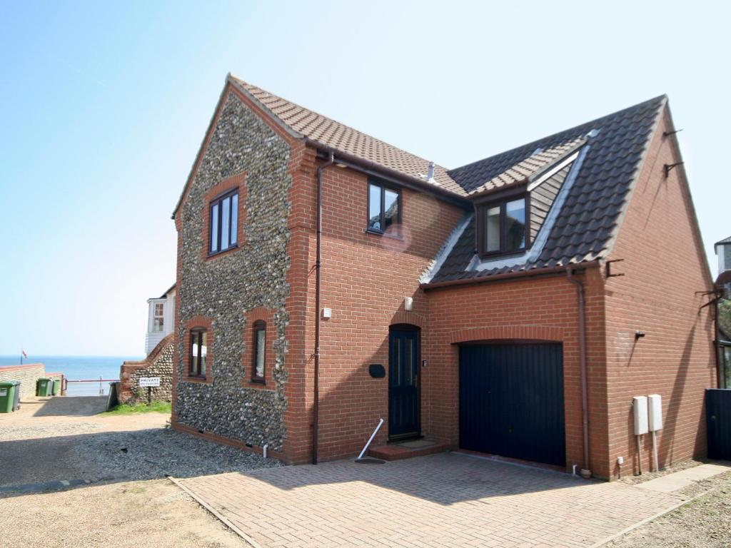 une maison en briques avec un garage dans une rue dans l'établissement Beach Retreat - E5558, à Mundesley