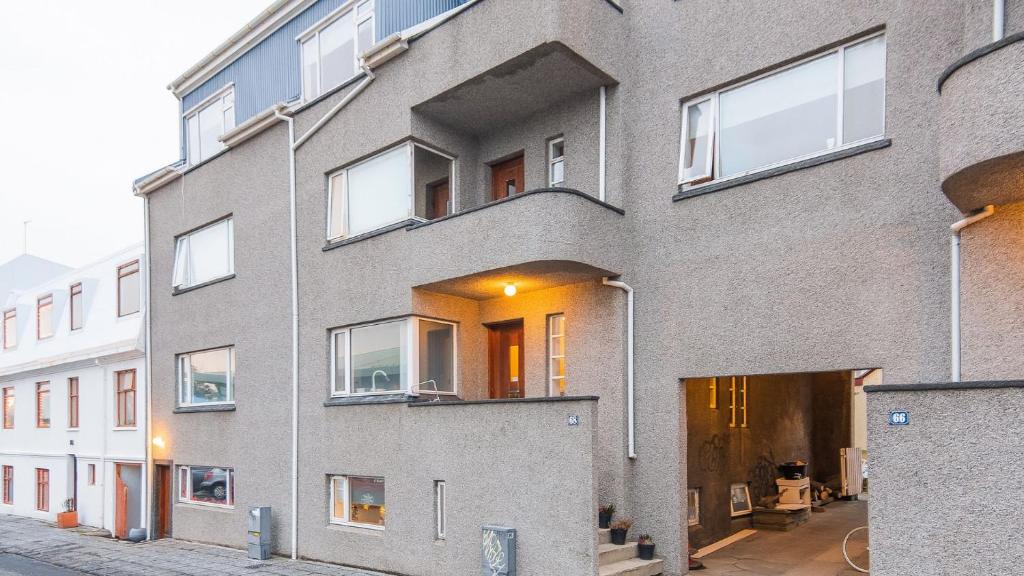 - un bâtiment en briques grises avec des fenêtres donnant sur une rue dans l'établissement Apartments Reykjavik, à Reykjavik