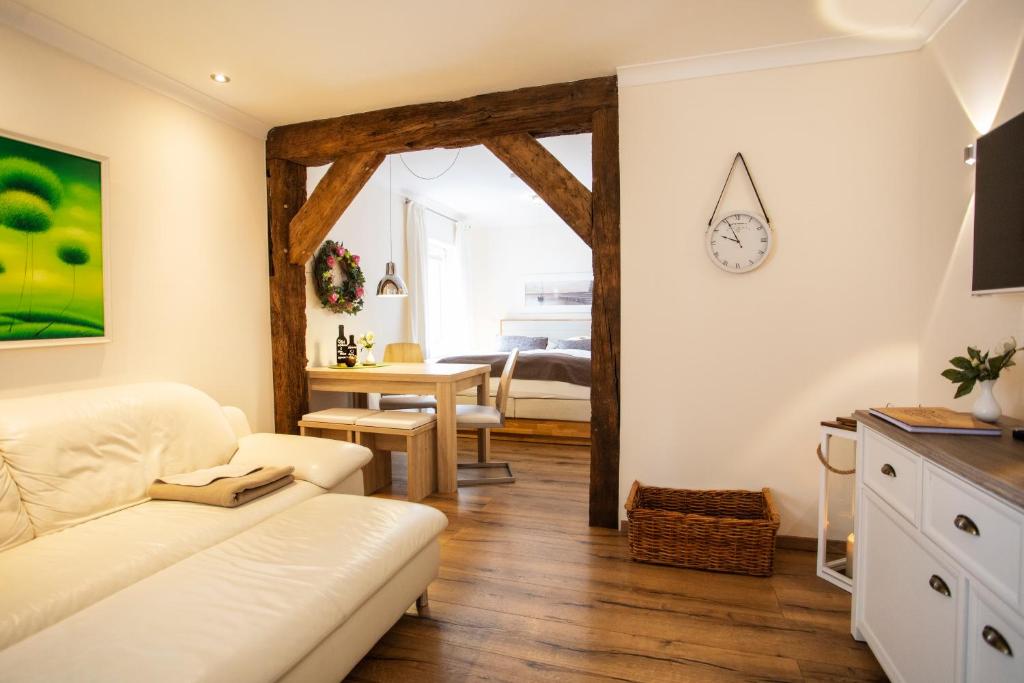 Altstadtjuwel @Conny's في بريلون: غرفة معيشة مع أريكة بيضاء وطاولة