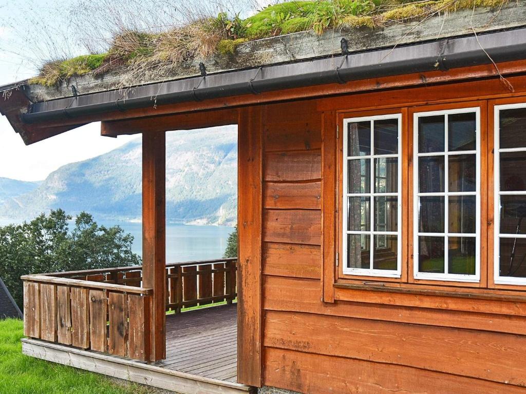 a wooden cabin with a deck with a view of the mountains at Holiday home olden X in Olden