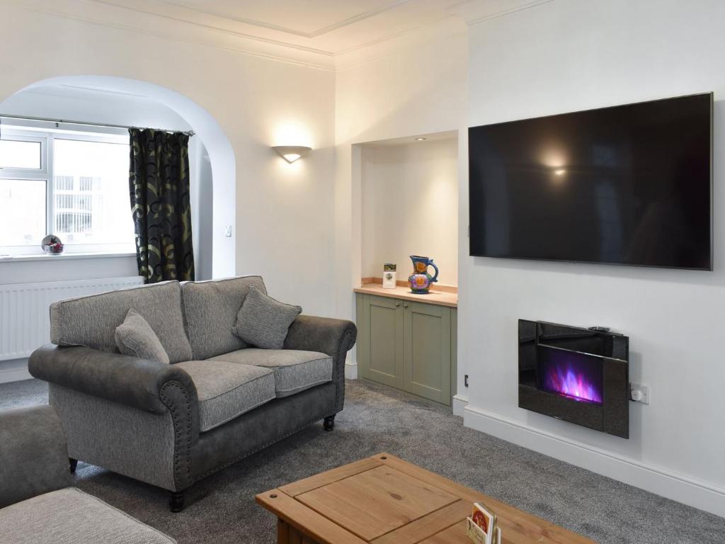 a living room with a couch and a fireplace at The Witheys in Woodhorn