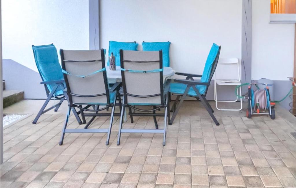 vier stoelen en een tafel met blauwe stoelen bij 2 Bedroom Amazing Apartment In Ferndorf in Ferndorf
