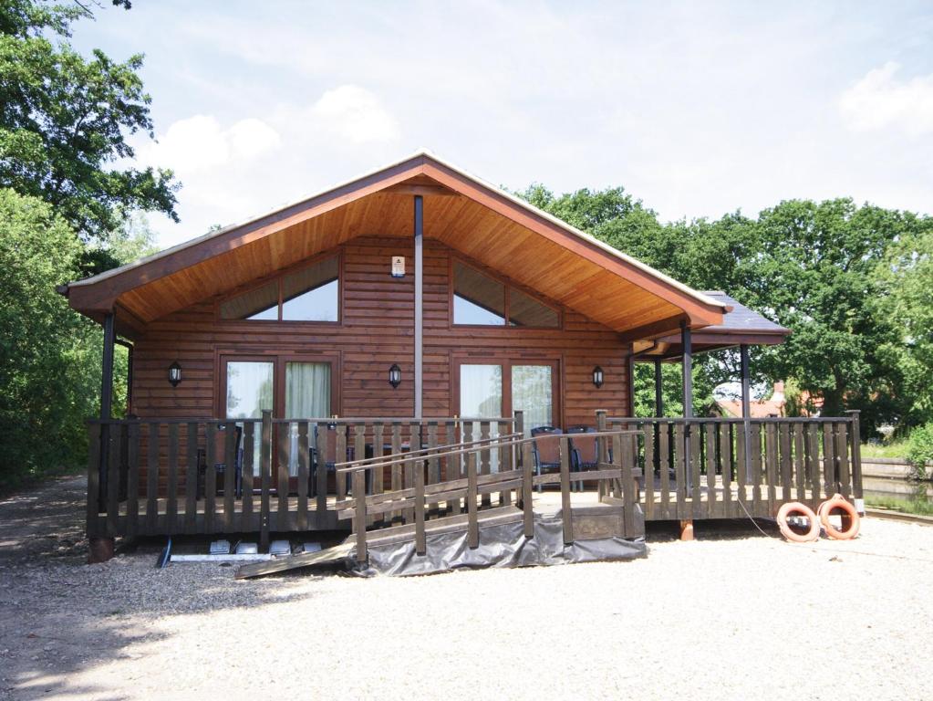 Cabaña de madera pequeña con valla de madera en Nautical Nook en Stalham