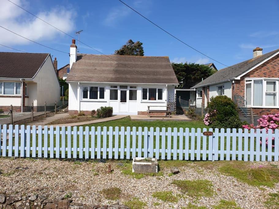 a white picket fence in front of a house at Atlantic Retreat - 5 minute stroll from the beach in Bude
