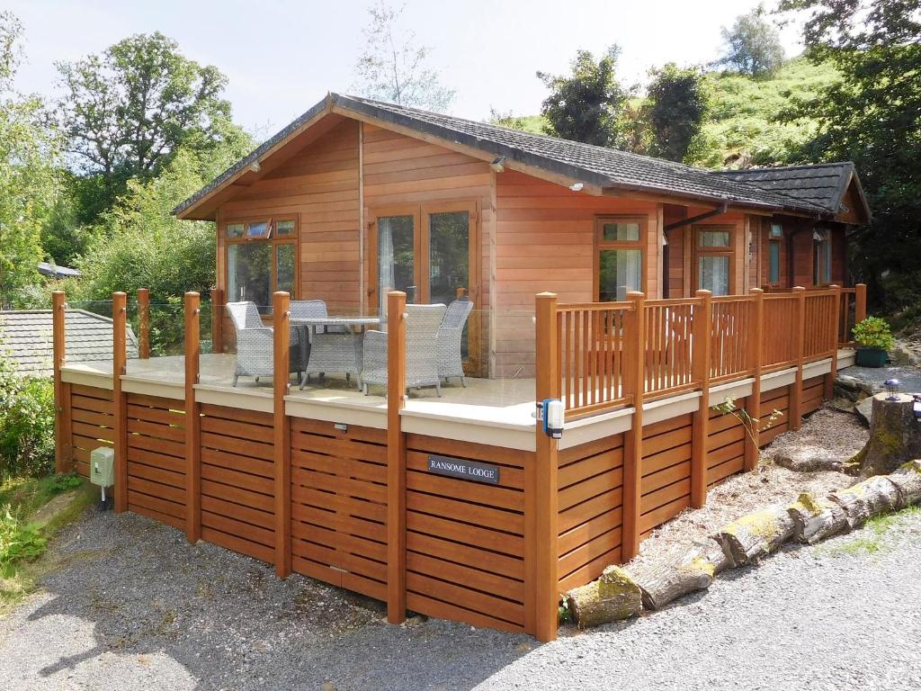 a wooden cabin with a deck and a patio at Ransome Lodge in High Nibthwaite